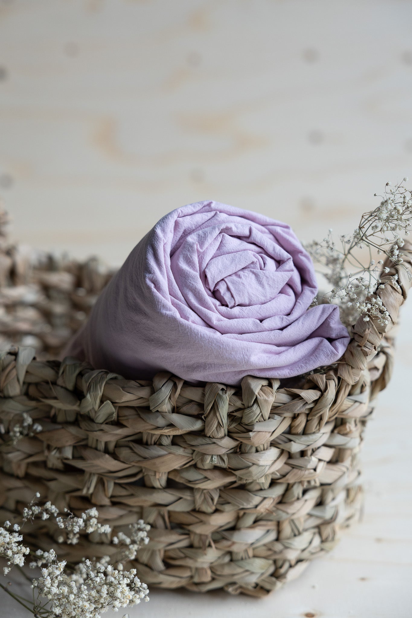 Lakan Crinkle Creamy Violet – ihoprullat i en flätad korg