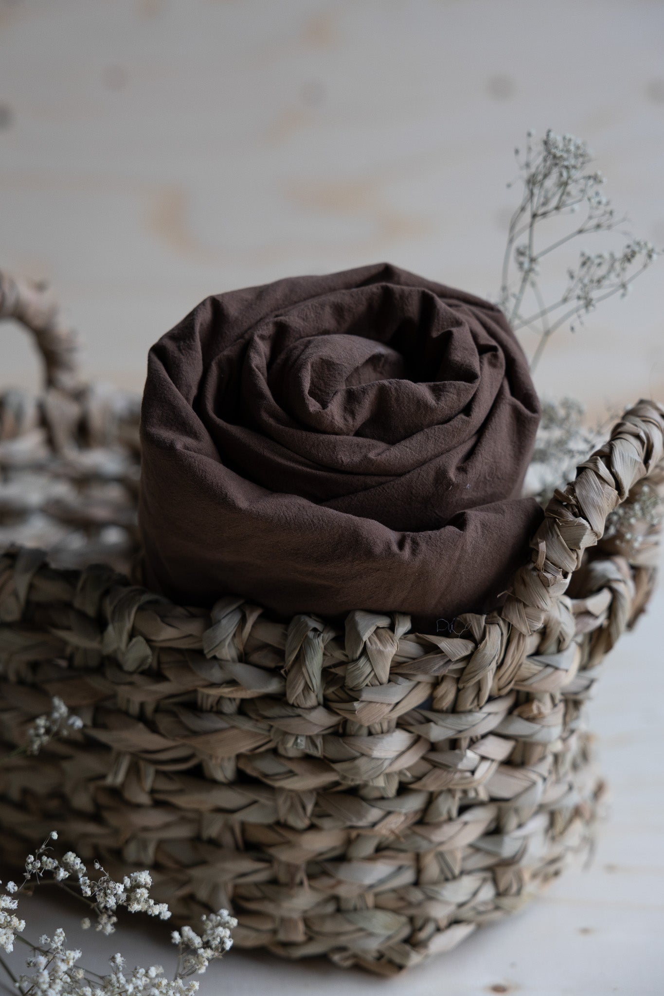 Lakan Crinkle Espresso – ihoprullat i en flätad korg