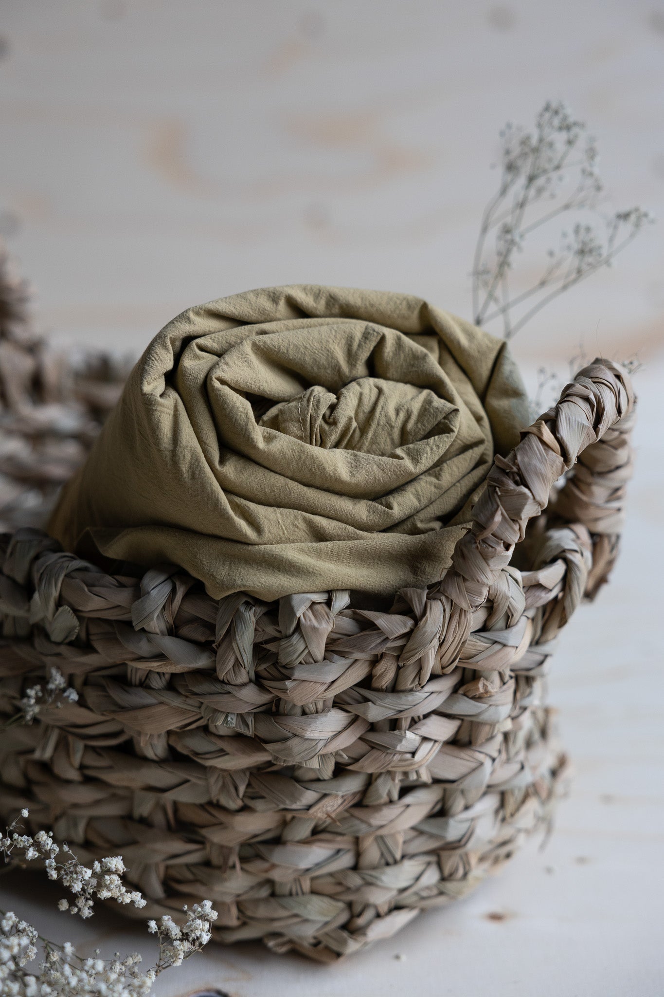 Lakan Crinkle Khaki Green – ihoprullat i en flätad korg