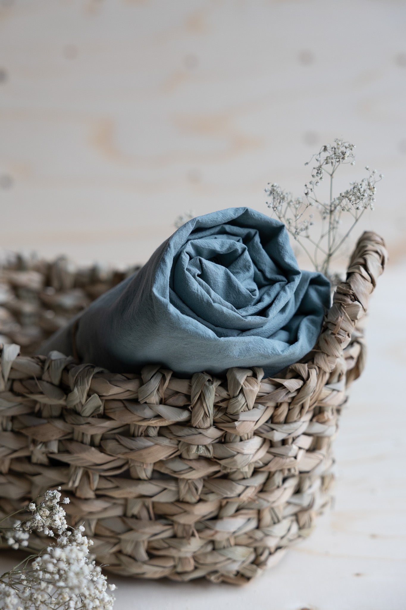 Lakan Crinkle Mineral Green – ihoprullat i en flätad korg