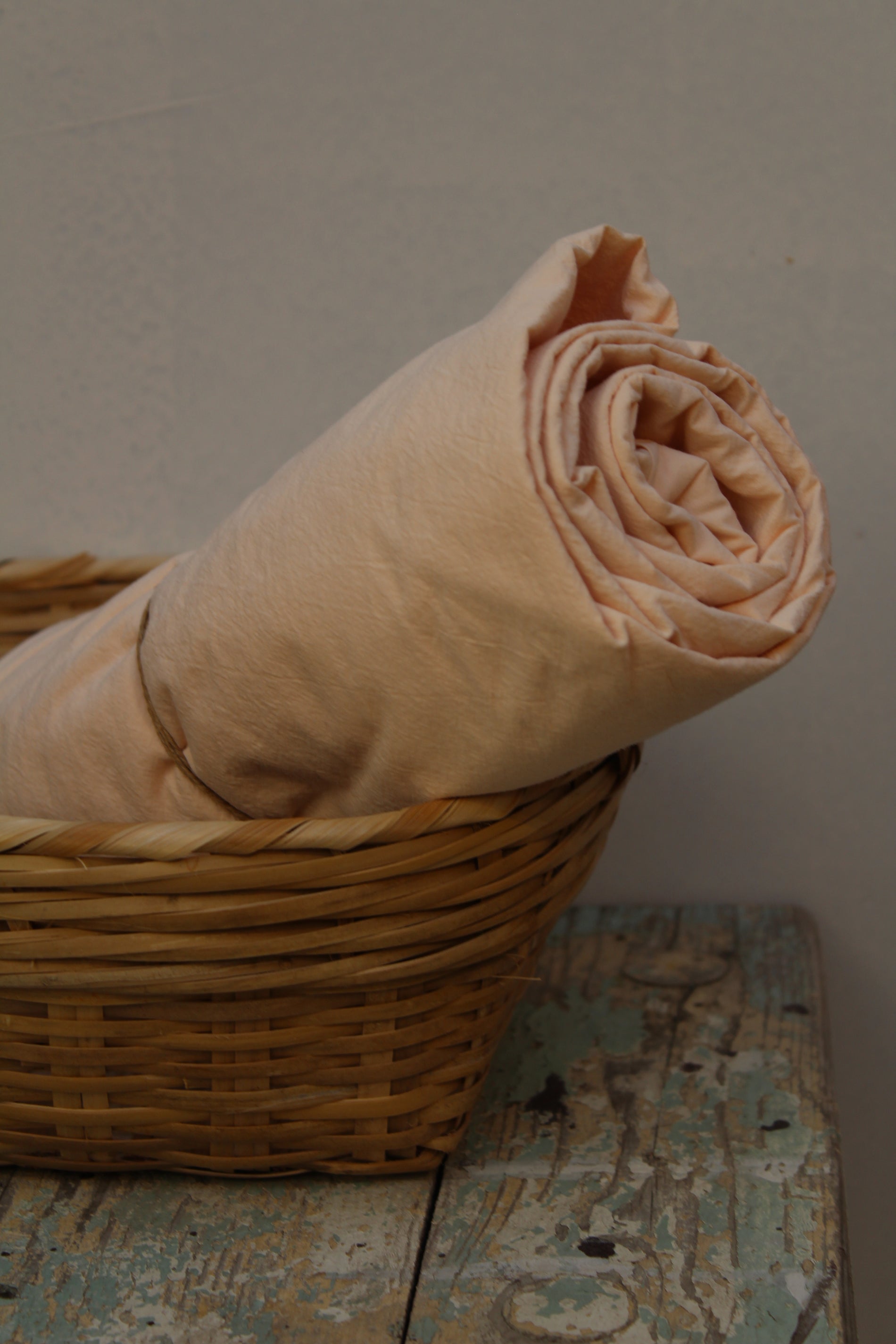 Lakan Crinkle Nude Pink – ihoprullat i en flätad korg
