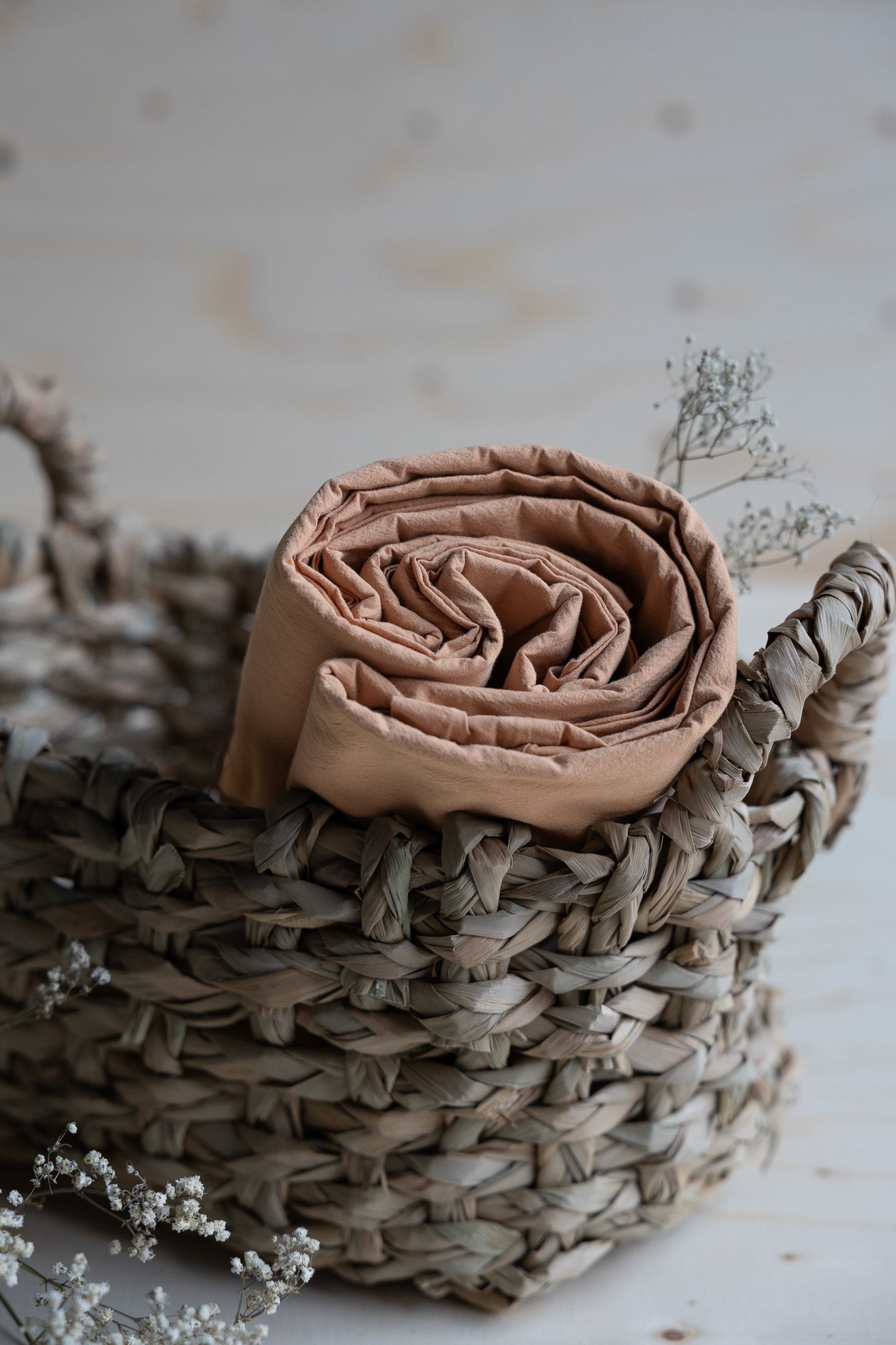Lakan Crinkle Peach Pink – ihoprullat i en flätad korg