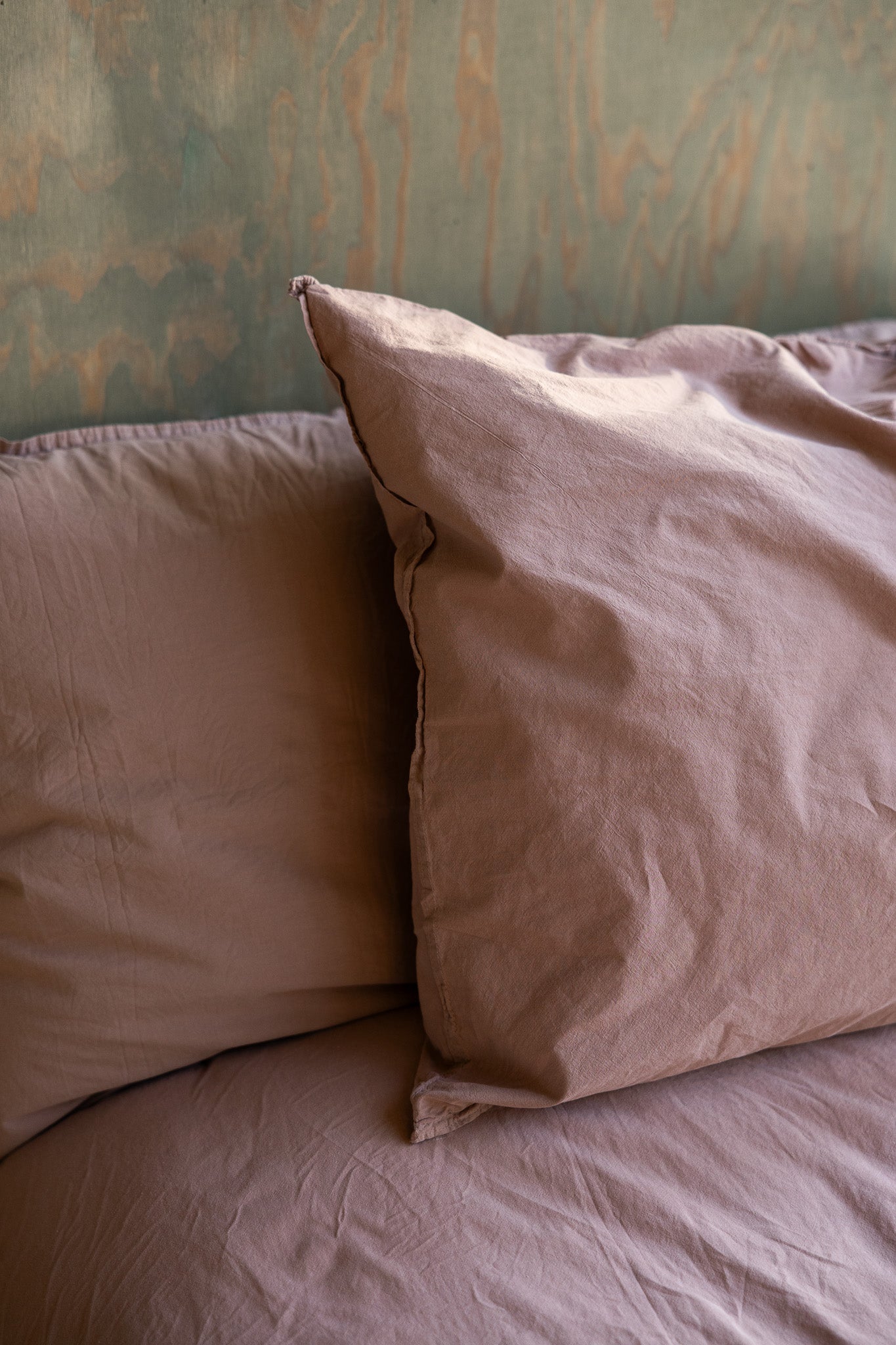 Kuddfodral Crinkle Rose Taupe – närbild av kudde på säng