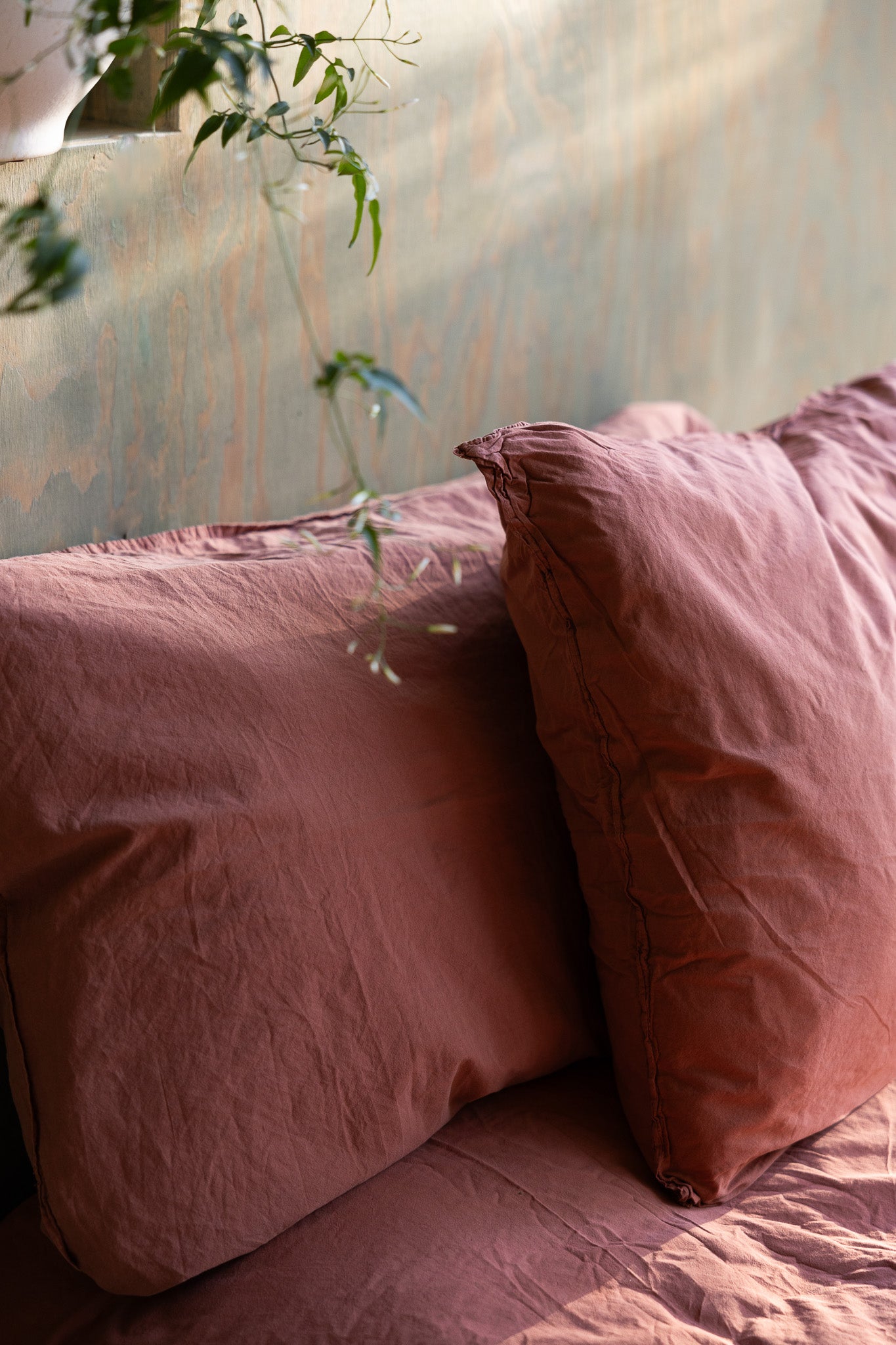 Kuddfodral Crinkle Terracotta – närbild av kudde på säng